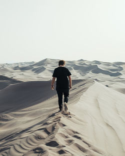 Rear view of man on desert land