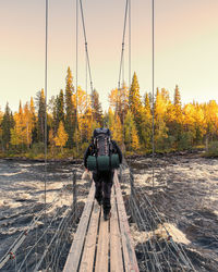 People on railroad track amidst trees against sky