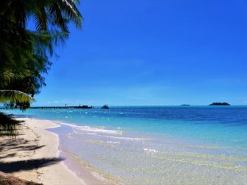 Scenic view of beach against clear blue sky