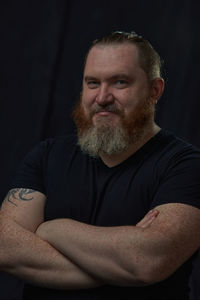 Portrait of senior man sitting against black background