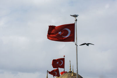 Low angle view of flag sign against sky