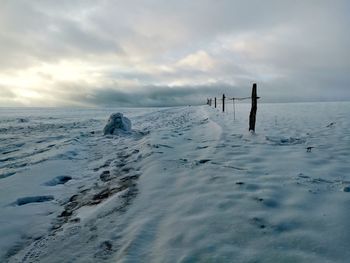 Scenic view of people on snow covered land against sky