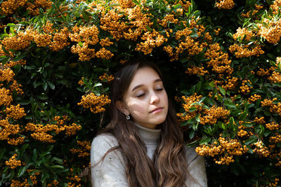 Portrait of beautiful young woman with red flower