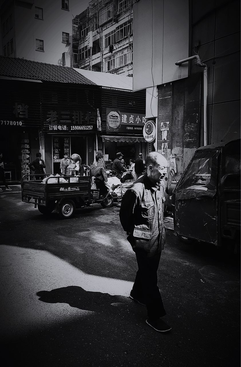 building exterior, full length, architecture, built structure, lifestyles, street, leisure activity, casual clothing, city, men, walking, standing, rear view, city life, shadow, road, night, sunlight