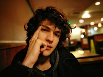 Close-up portrait of handsome young man sitting in restaurant