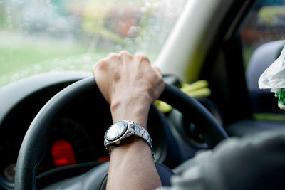 Cropped image of of man driving car