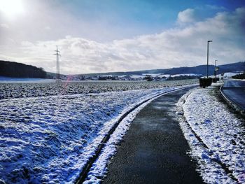 Snow covered road against sky