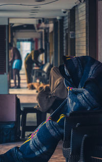 Man wrapped in blanket sitting at corridor