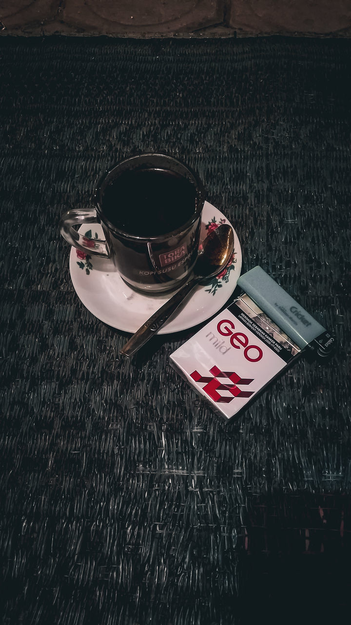 HIGH ANGLE VIEW OF COFFEE CUP ON TABLE AT NIGHT