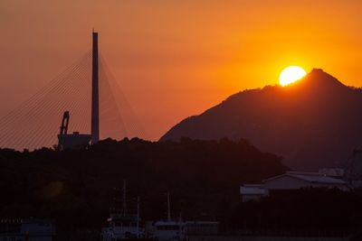 Silhouette of suspension bridge against sky during sunset