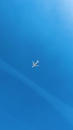 Low angle view of airplane flying against blue sky