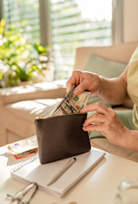 Midsection of woman using digital tablet on table