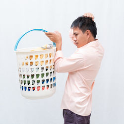 Side view of man looking at camera over white background