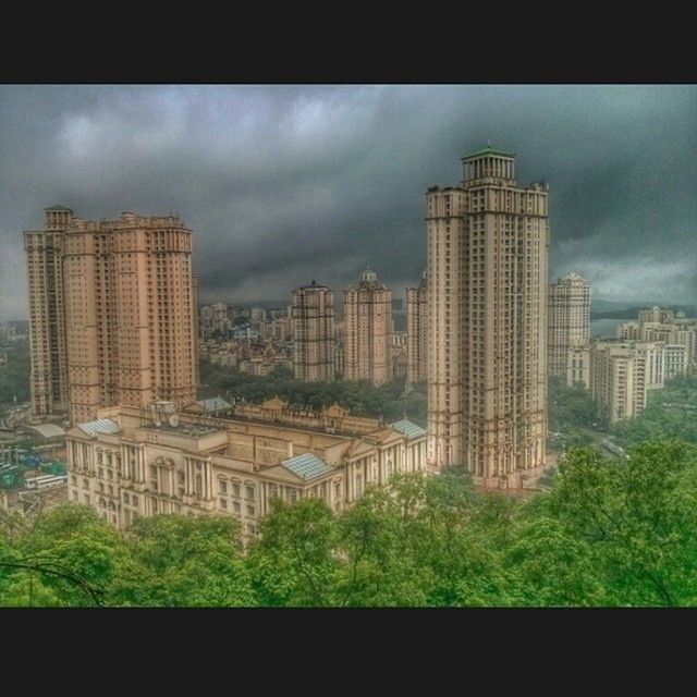 building exterior, architecture, built structure, sky, city, cloud - sky, cloudy, cityscape, auto post production filter, skyscraper, tree, transfer print, overcast, modern, cloud, tower, building, residential building, weather, office building