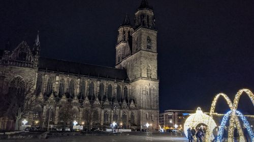 Illuminated building against sky at night in city