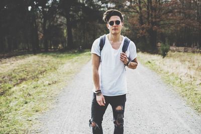 Full length of young man wearing sunglasses on road