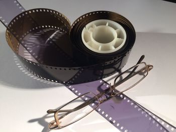 Close-up of film reel and eyeglasses on table