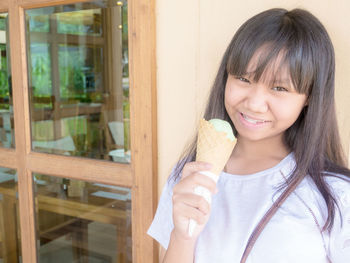 Portrait of a smiling girl looking through window