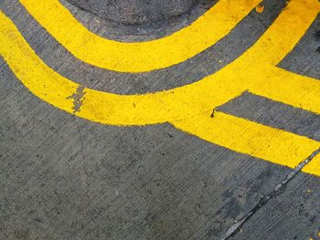 High angle view of yellow arrow symbol on road