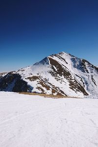 Scenic view of snowcapped mountains against clear blue sky