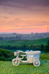 Wicker basket on field against sky during sunset
