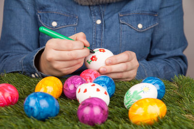 Midsection of woman painting easter eggs at home