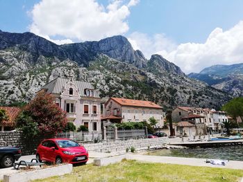 Cars on buildings by mountains against sky