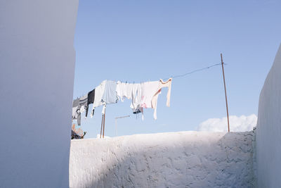 Low angle view of clothes drying against clear sky