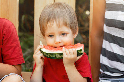 Portrait of cute boy eating watermelon outdoors