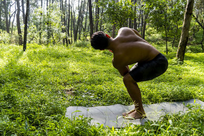 Mexican man doing yoga and stretching in the forest, mexico