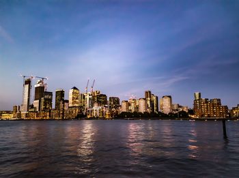 River by buildings against sky in city