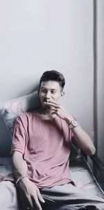 Portrait of young man sitting on chair at home