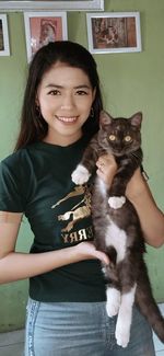 Portrait of smiling young woman with cat