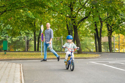 Rear view of man riding bicycle on road