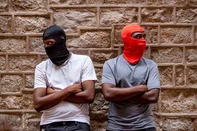 Young men wearing mask against wall