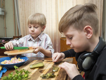 Portrait of boy holding food on table