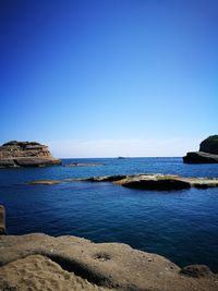 Scenic view of sea against clear blue sky