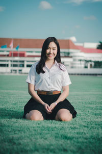 Portrait of a smiling young woman sitting outdoors