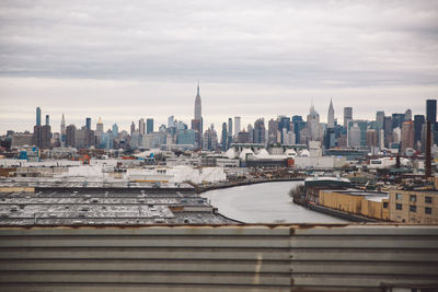 View of cityscape against cloudy sky