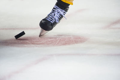 Low section of person playing ice hokey in rink