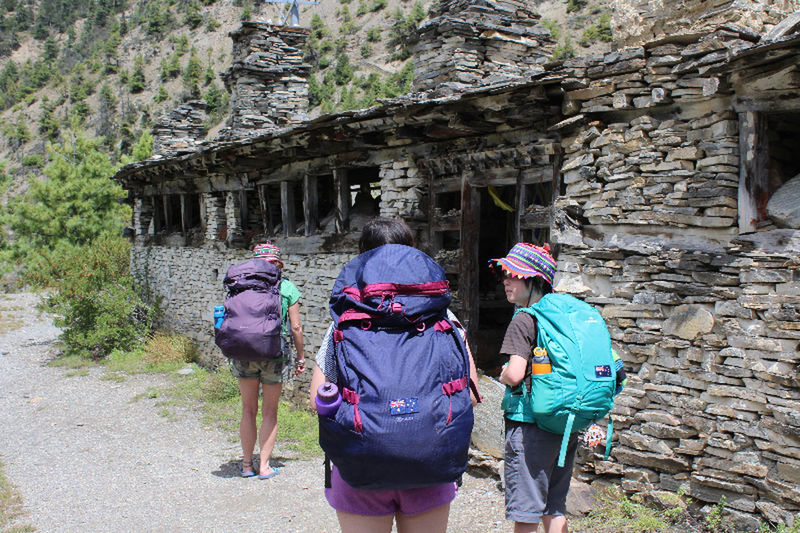 REAR VIEW OF PEOPLE WALKING ON COBBLESTONE