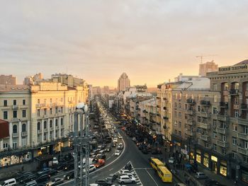 High angle view of cars moving on road amidst buildings against sky