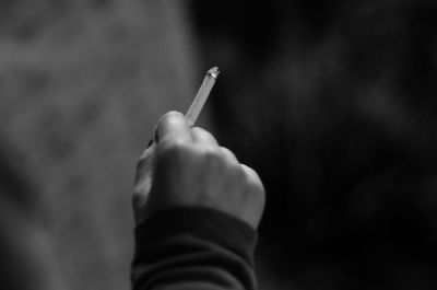 Close-up of hand holding cigarette