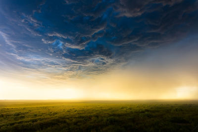 Sunset light illuminates haze beneath dramatic storm clouds in colorado.