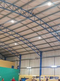 Low angle view of illuminated lights on ceiling of building