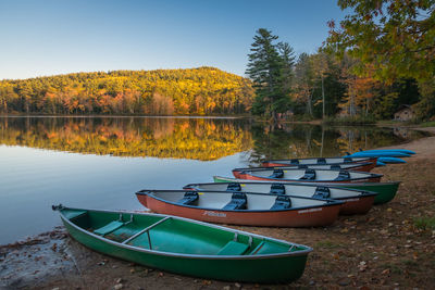 Boats moored in lake against sky during autumn