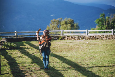 Man photographing woman standing on mountain road