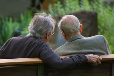 Rear view of senior men sitting on bench