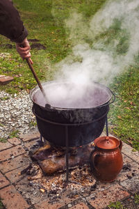 Cropped hand preparing food in yard