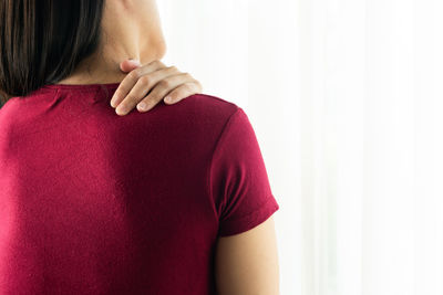 Rear view of woman standing against red background